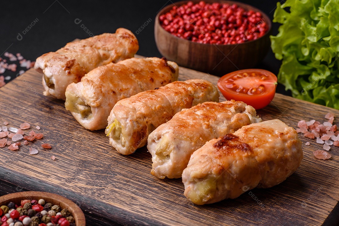 Delicioso rolo de porco ou frango assado com cogumelos, especiarias e ervas dentro sobre um fundo escuro de concreto