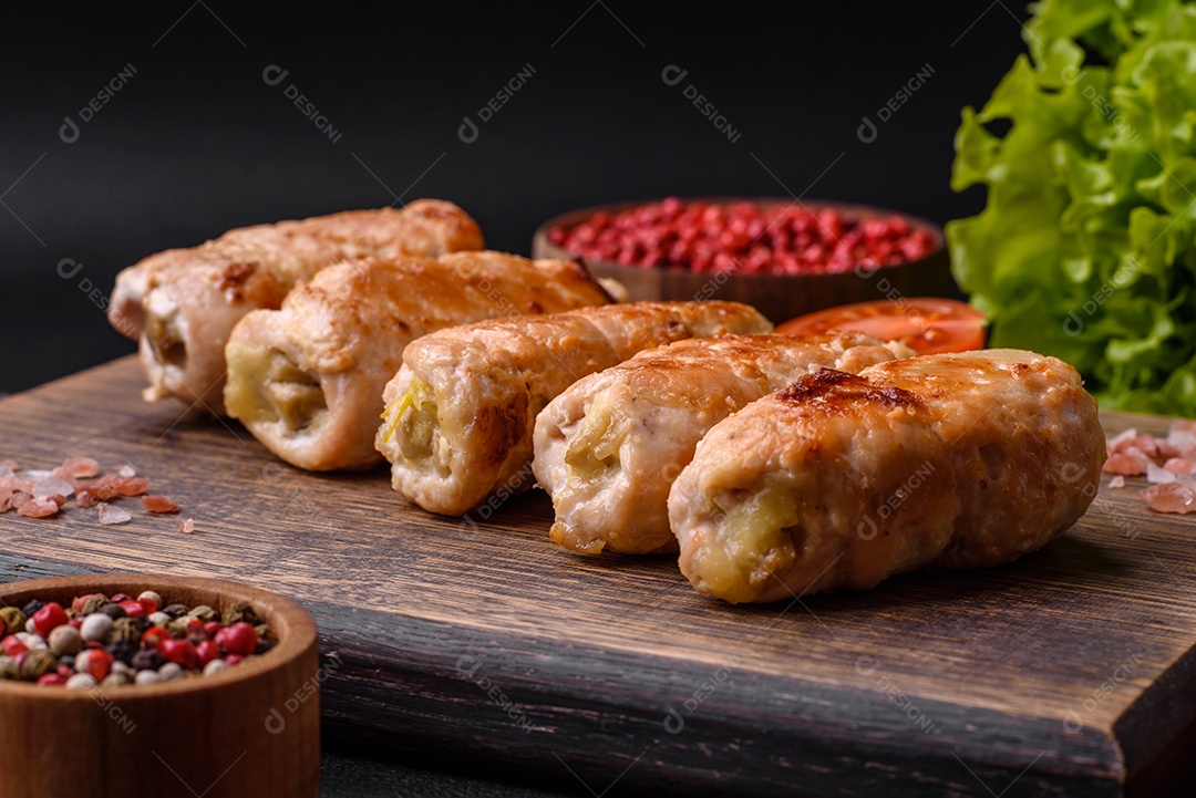 Delicioso rolo de porco ou frango assado com cogumelos, especiarias e ervas dentro sobre um fundo escuro de concreto