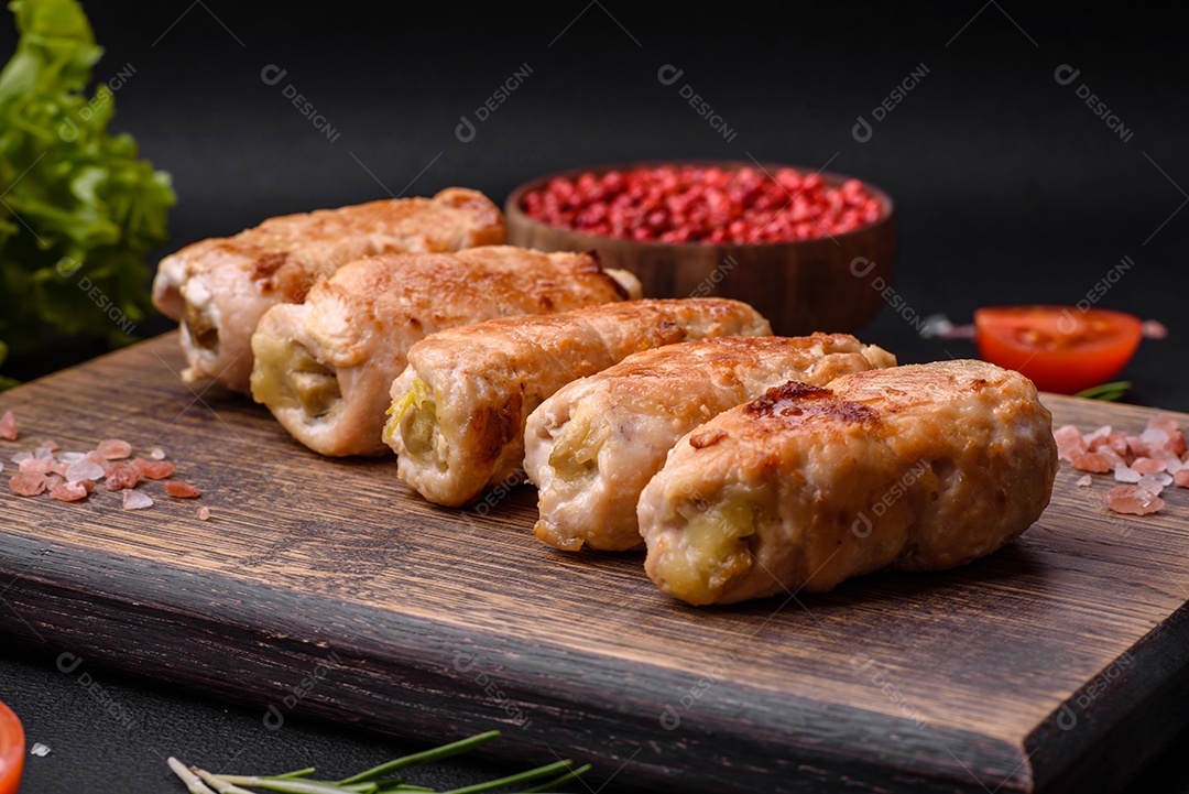 Delicioso rolo de porco ou frango assado com cogumelos, especiarias e ervas dentro sobre um fundo escuro de concreto