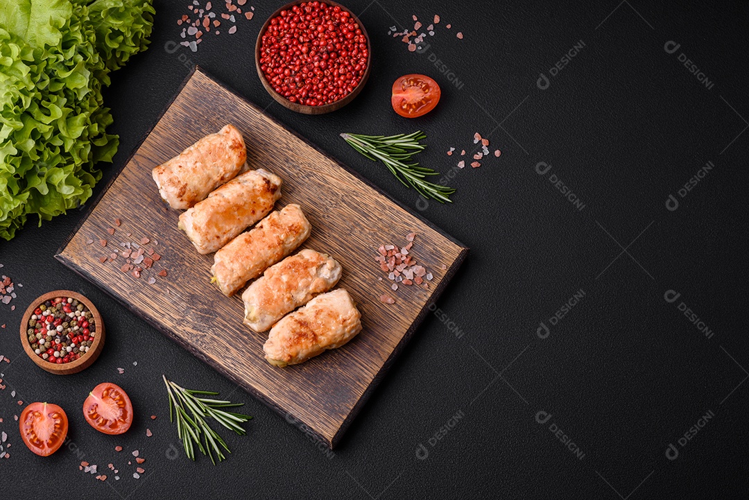 Delicioso rolo de porco ou frango assado com cogumelos, especiarias e ervas dentro sobre um fundo escuro de concreto