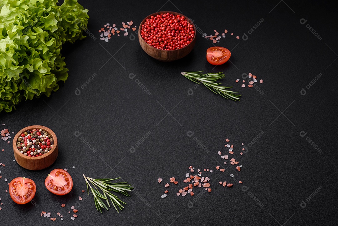 Especiarias, ervas e hortaliças dentro sobre um fundo escuro de concreto