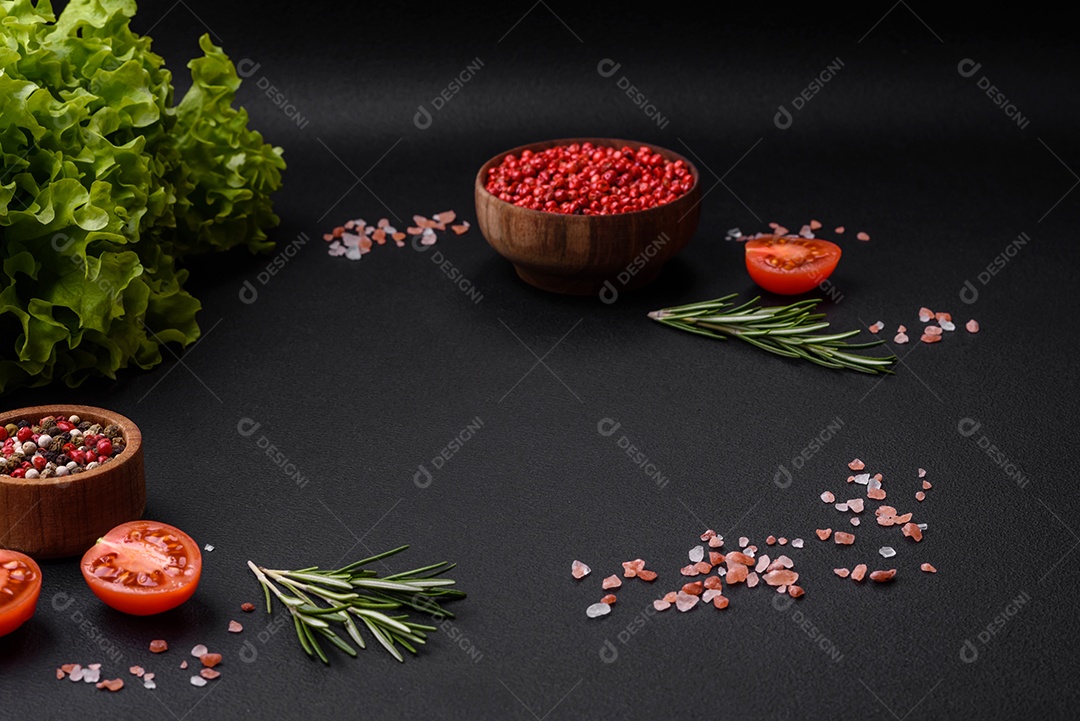 Especiarias, ervas e hortaliças dentro sobre um fundo escuro de concreto