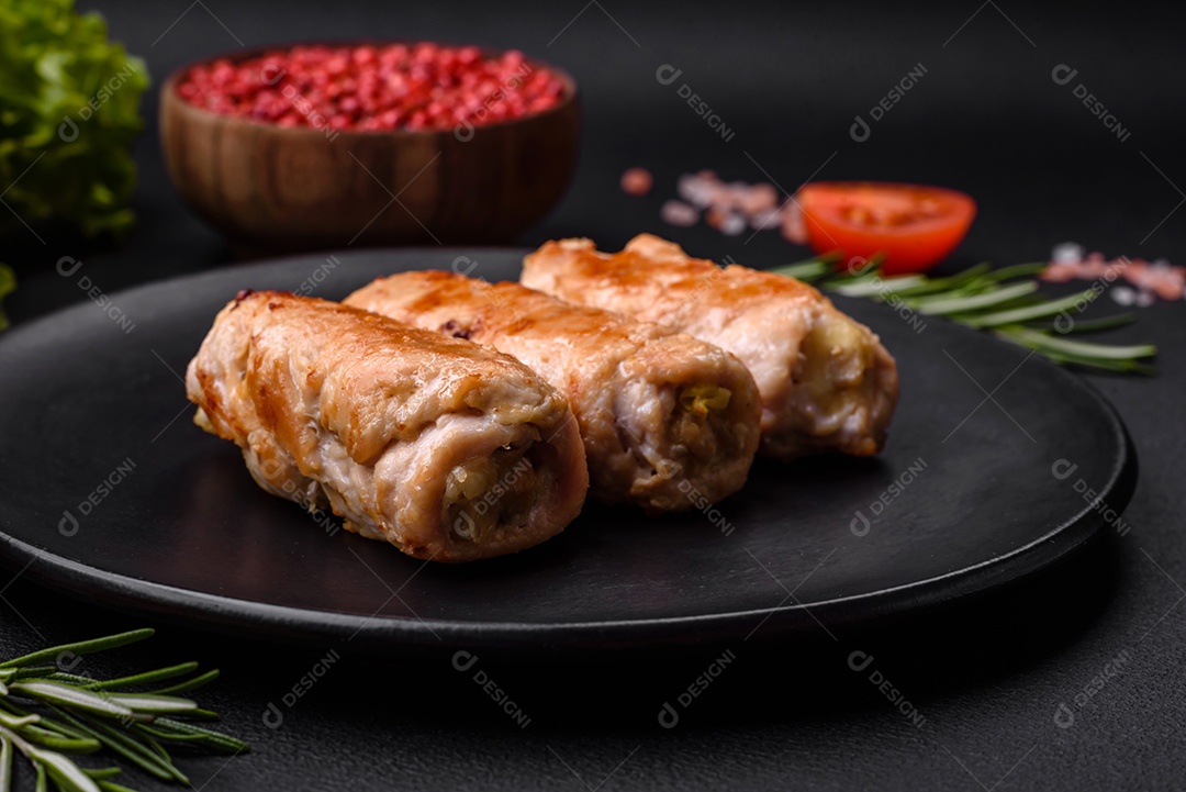 Delicioso rolo de porco ou frango assado com cogumelos, especiarias e ervas dentro sobre um fundo escuro de concreto