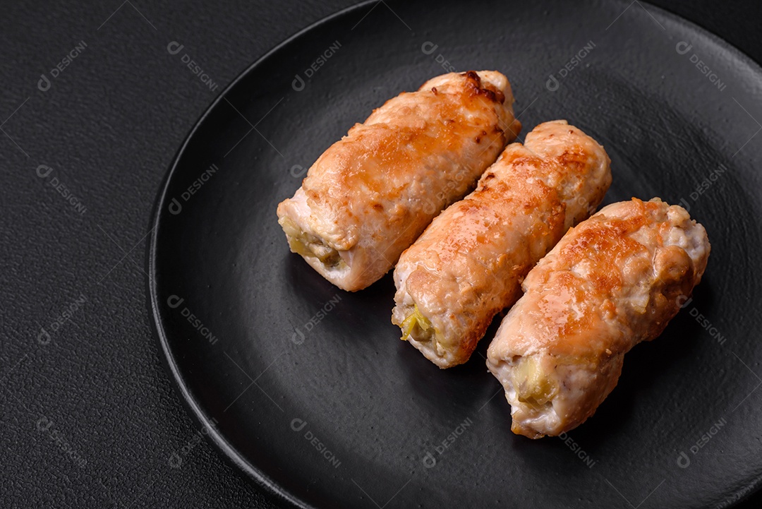 Delicioso rolo de porco ou frango assado com cogumelos, especiarias e ervas dentro sobre um fundo escuro de concreto
