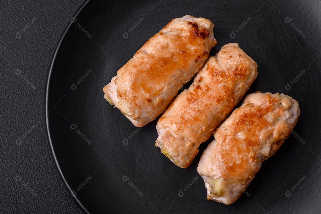Delicioso rolo de porco ou frango assado com cogumelos, especiarias e ervas dentro sobre um fundo escuro de concreto