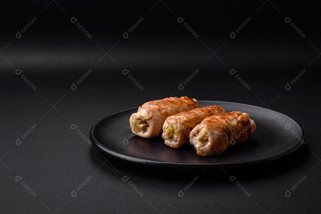 Delicioso rolo de porco ou frango assado com cogumelos, especiarias e ervas dentro sobre um fundo escuro de concreto