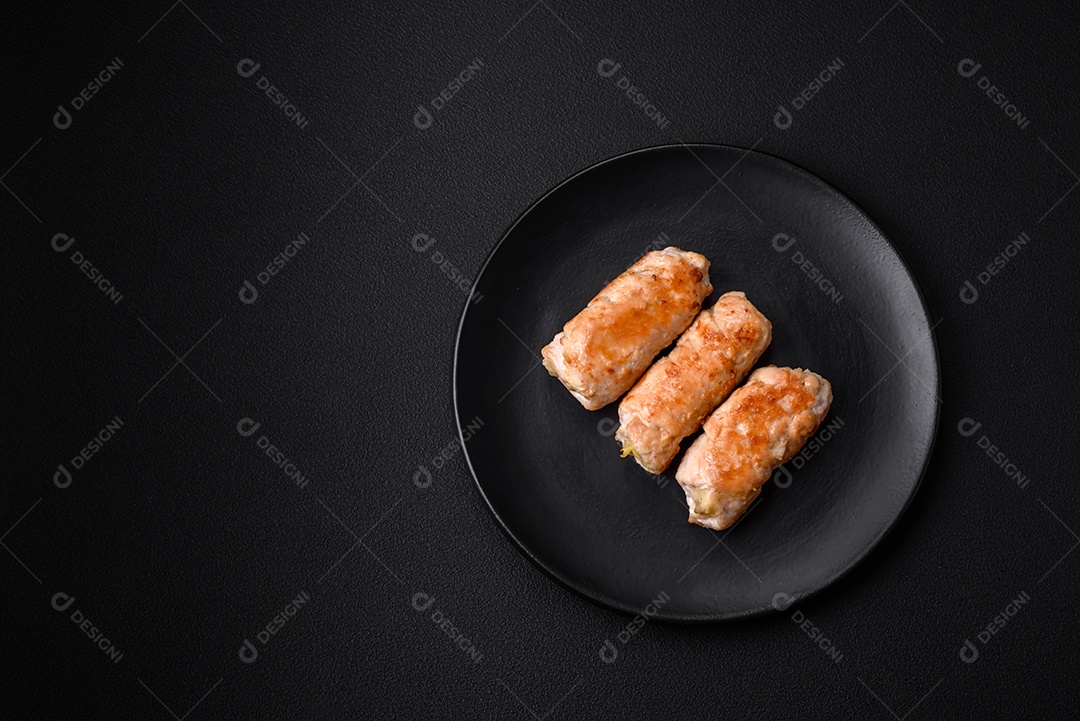 Delicioso rolo de porco ou frango assado com cogumelos, especiarias e ervas dentro sobre um fundo escuro de concreto