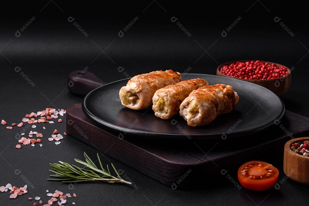 Delicioso rolo de porco ou frango assado com cogumelos, especiarias e ervas dentro sobre um fundo escuro de concreto