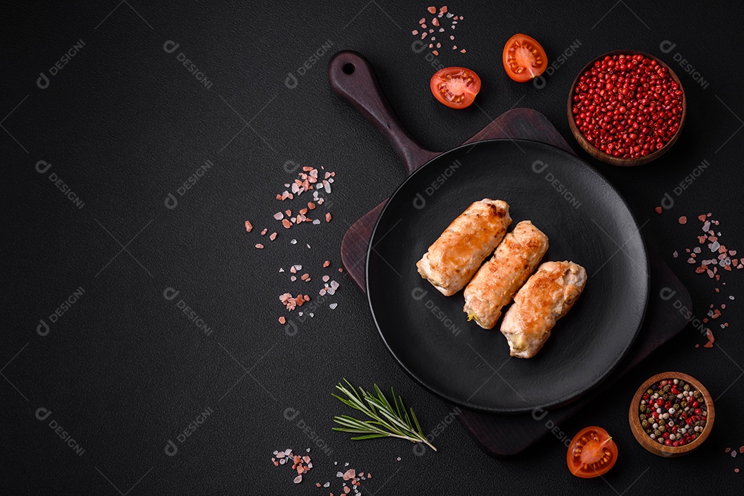 Delicioso rolo de porco ou frango assado com cogumelos, especiarias e ervas dentro sobre um fundo escuro de concreto