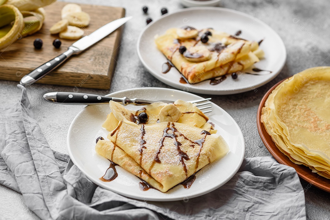 Deliciosas panquecas frescas com mel e frutas em um fundo de concreto texturizado. Comida saudável e útil