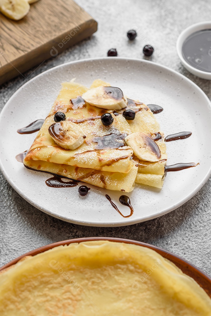Deliciosas panquecas frescas com mel e frutas em um fundo de concreto texturizado. Comida saudável e útil