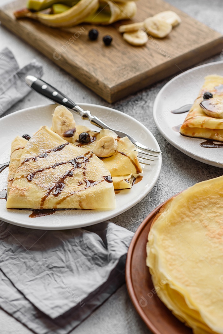 Deliciosas panquecas frescas com mel e frutas em um fundo de concreto texturizado. Comida saudável e útil