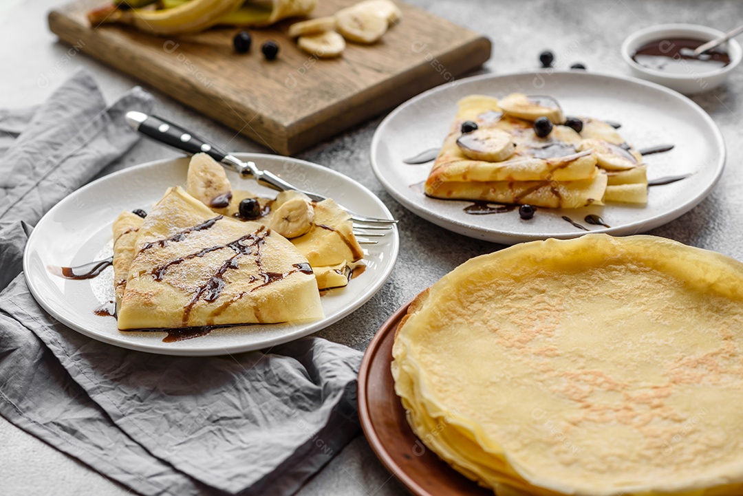 Deliciosas panquecas frescas com mel e frutas em um fundo de concreto texturizado. Comida saudável e útil