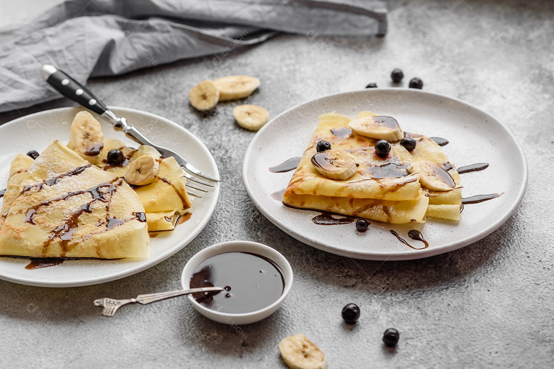 Deliciosas panquecas frescas com mel e frutas em um fundo de concreto texturizado. Comida saudável e útil