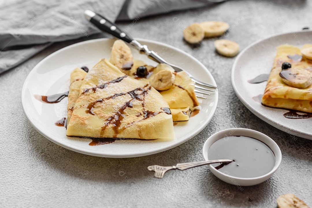 Deliciosas panquecas frescas com mel e frutas em um fundo de concreto texturizado. Comida saudável e útil