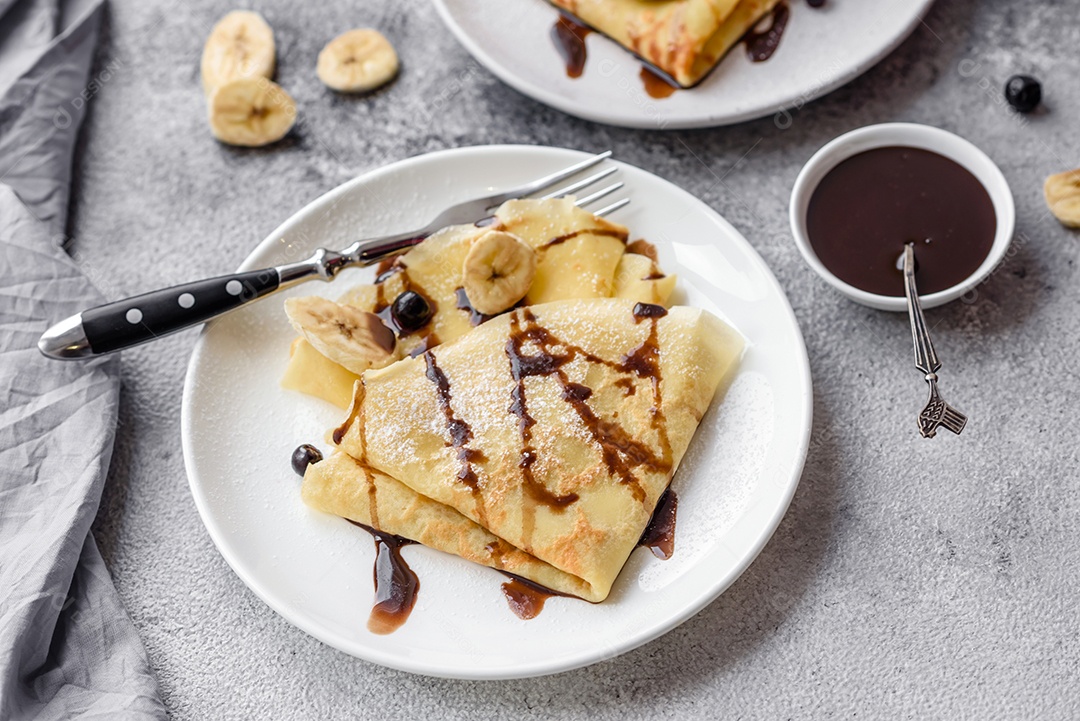Deliciosas panquecas frescas com mel e frutas em um fundo de concreto texturizado. Comida saudável e útil