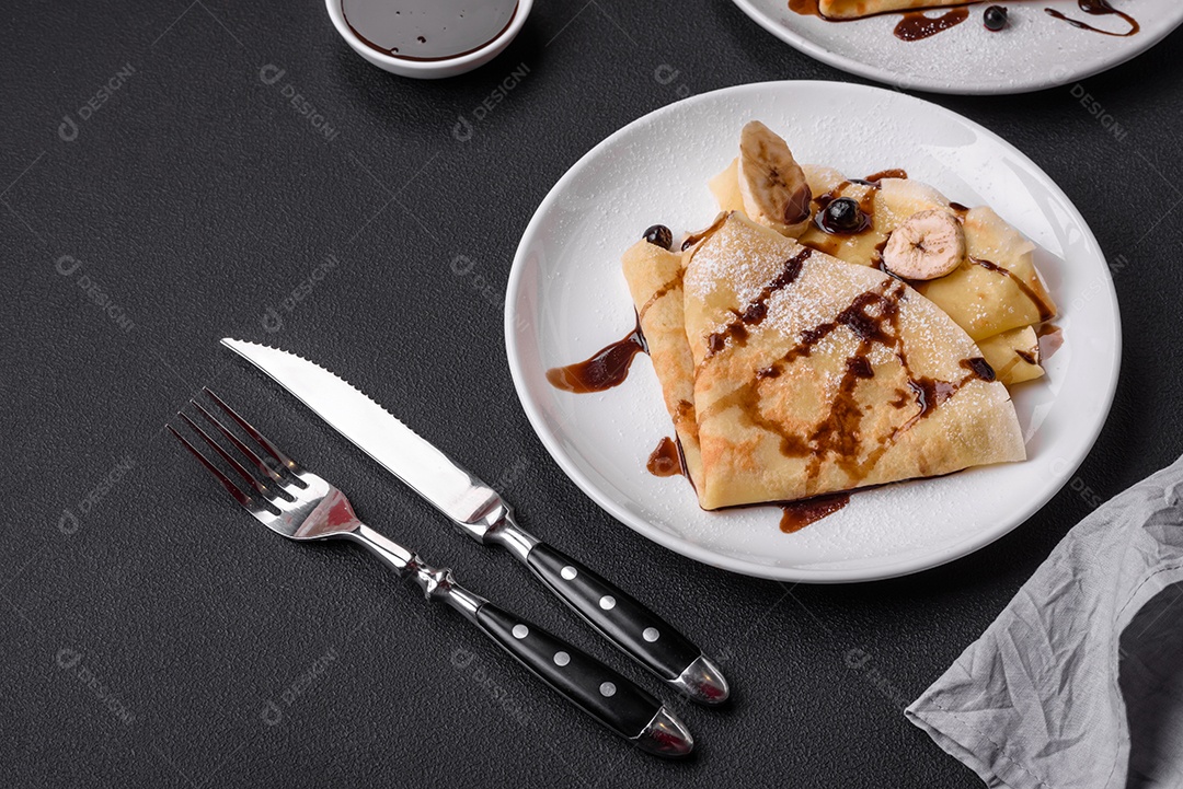 Deliciosas panquecas frescas com mel e frutas em um fundo de concreto texturizado. Comida saudável e útil