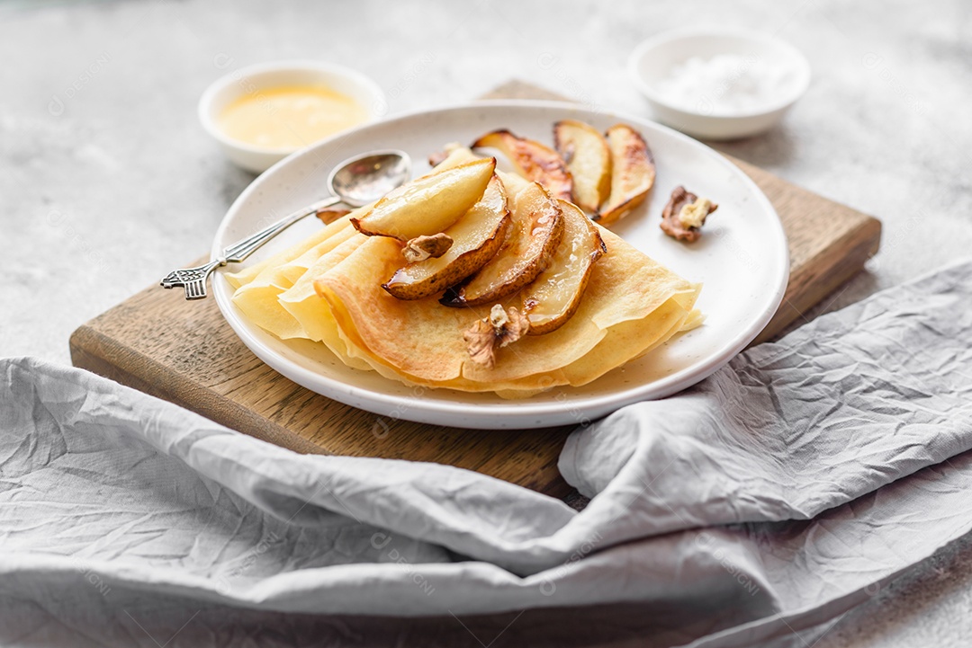 Deliciosas panquecas frescas com mel e frutas em um fundo de concreto texturizado. Comida saudável e útil
