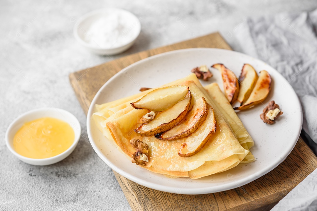 Deliciosas panquecas frescas com mel e frutas em um fundo de concreto texturizado. Comida saudável e útil