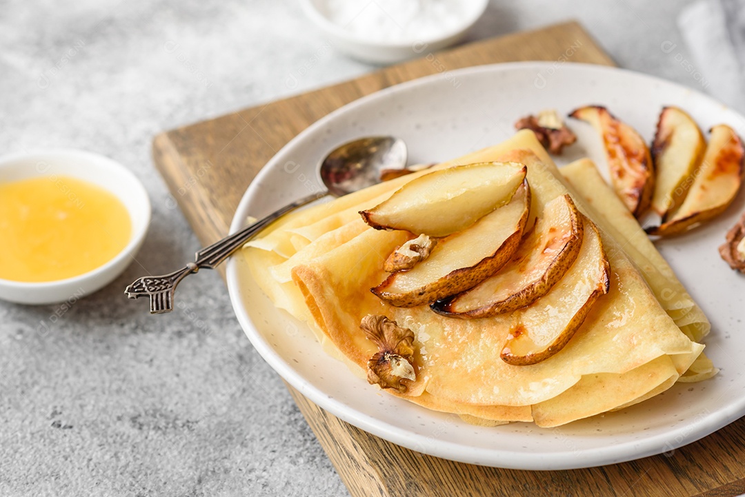 Deliciosas panquecas frescas com mel e frutas em um fundo de concreto texturizado. Comida saudável e útil