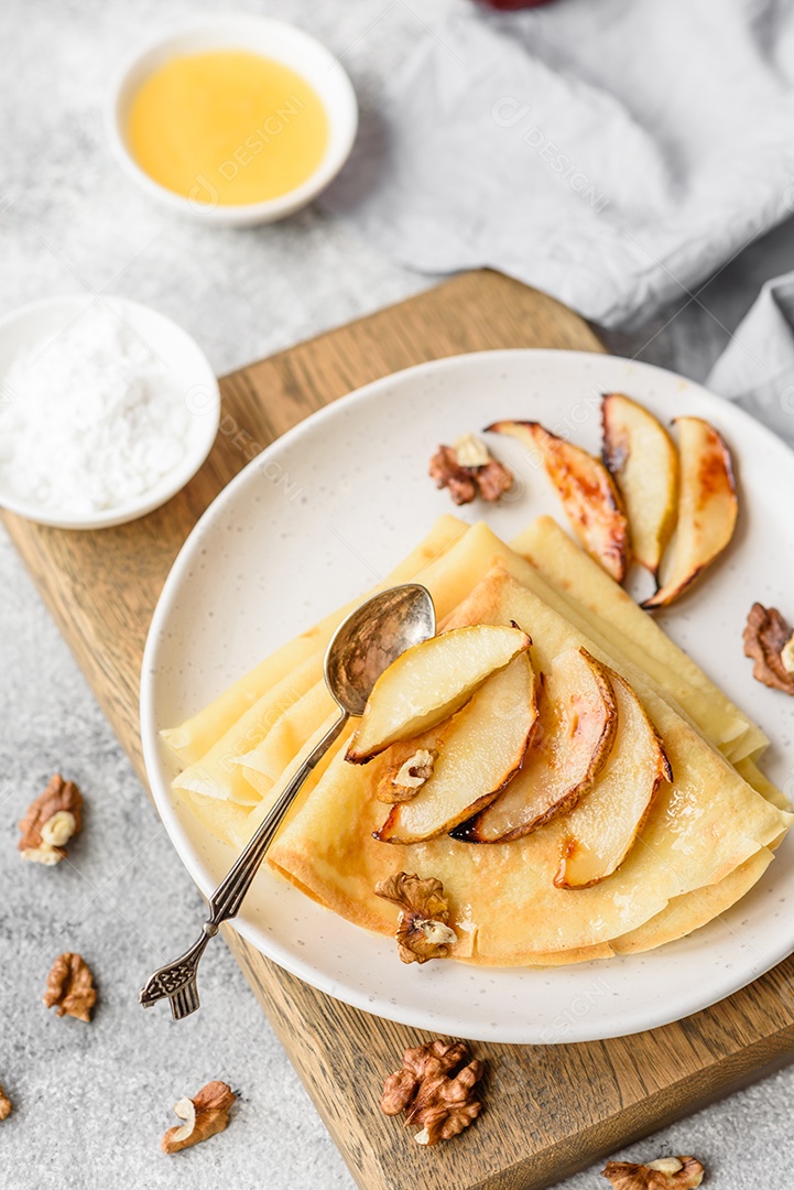 Deliciosas panquecas frescas com mel e frutas em um fundo de concreto texturizado. Comida saudável e útil