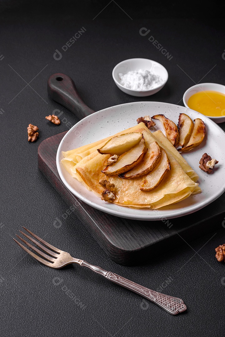 Deliciosas panquecas frescas com mel e frutas em um fundo de concreto texturizado. Comida saudável e útil