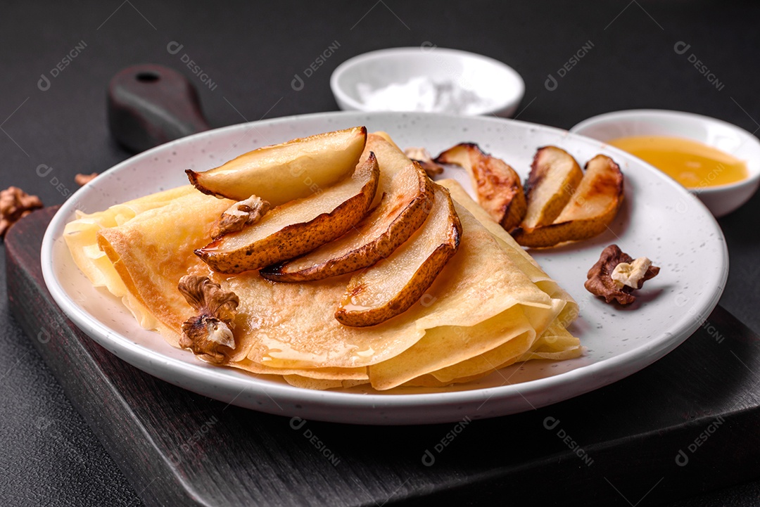 Deliciosas panquecas frescas com mel e frutas em um fundo de concreto texturizado. Comida saudável e útil