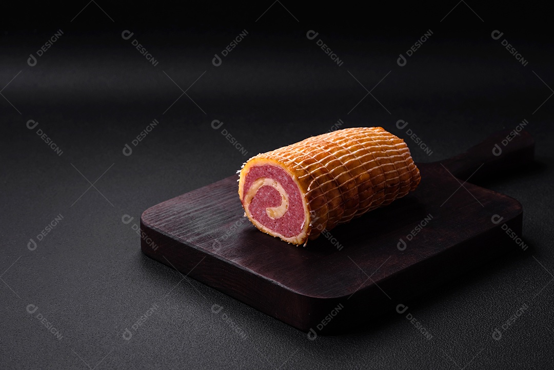 Rolo delicioso com carne, queijo, cogumelos, especiarias e ervas sobre um fundo de concreto texturizado escuro