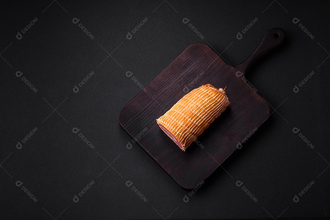 Rolo delicioso com carne, queijo, cogumelos, especiarias e ervas sobre um fundo de concreto texturizado escuro