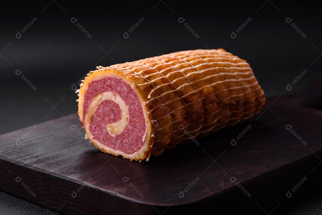 Rolo delicioso com carne, queijo, cogumelos, especiarias e ervas sobre um fundo de concreto texturizado escuro