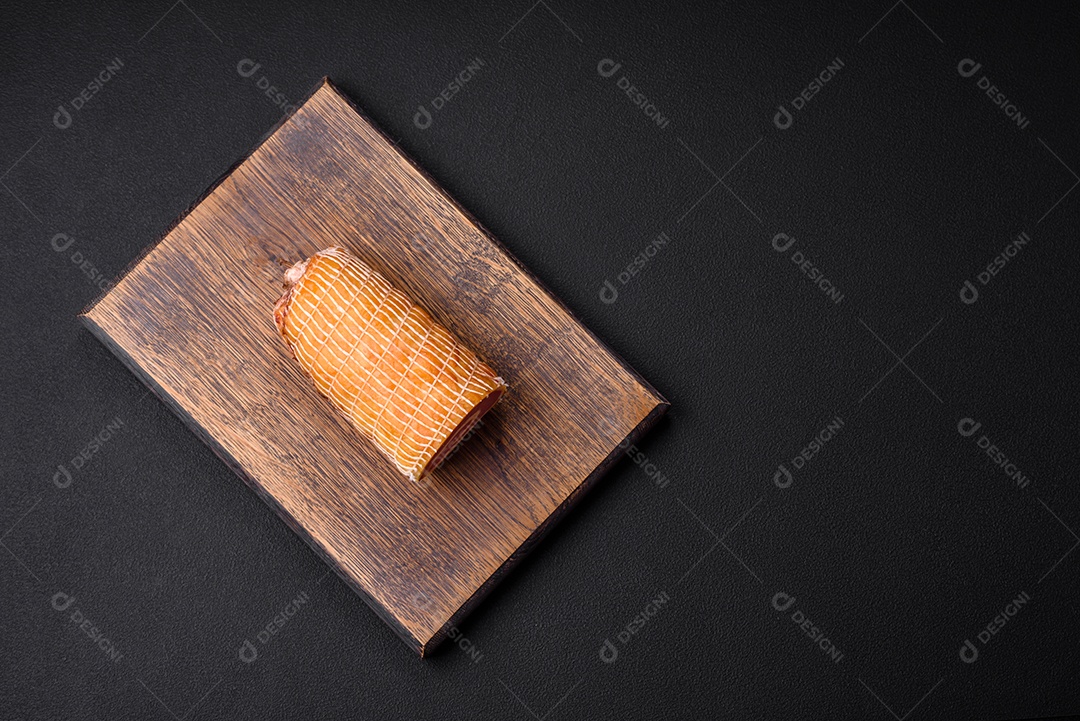 Rolo delicioso com carne, queijo, cogumelos, especiarias e ervas sobre um fundo de concreto texturizado escuro