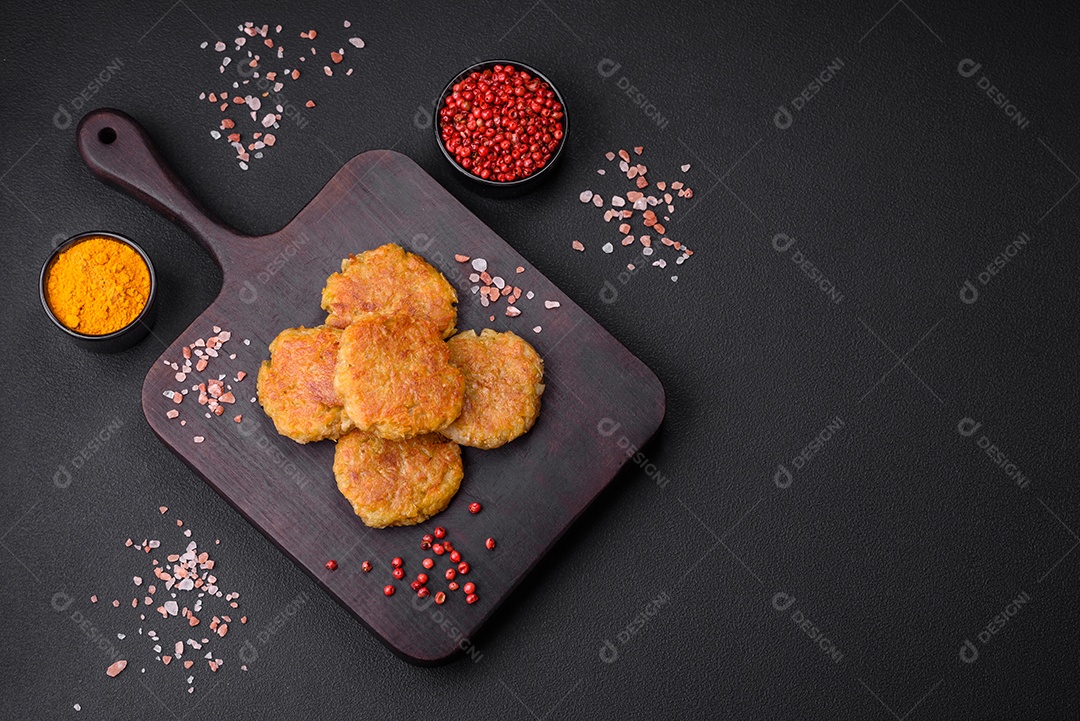 Delicioso prato vegetariano ou vegano em forma de costeletas ou hambúrgueres consistindo de batatas, cenouras, cebolas e feijões sobre um fundo escuro de concreto