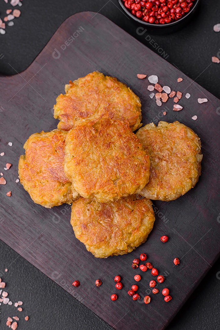 Delicioso prato vegetariano ou vegano em forma de costeletas ou hambúrgueres consistindo de batatas, cenouras, cebolas e feijões sobre um fundo escuro de concreto