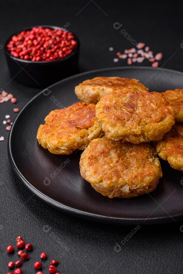 Delicioso prato vegetariano ou vegano em forma de costeletas ou hambúrgueres consistindo de batatas, cenouras, cebolas e feijões sobre um fundo escuro de concreto