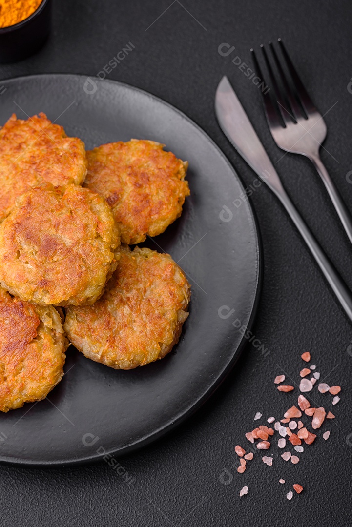 Delicioso prato vegetariano ou vegano em forma de costeletas ou hambúrgueres consistindo de batatas, cenouras, cebolas e feijões sobre um fundo escuro de concreto