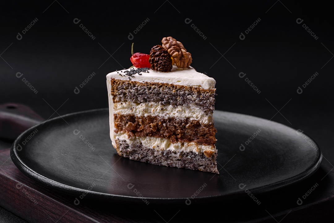 Delicioso lindo pedaço de bolo com creme e frutas em uma placa de cerâmica preta sobre um fundo escuro de concreto