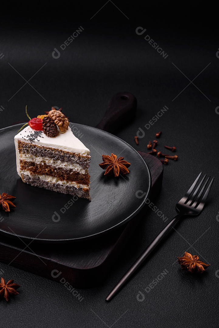 Delicioso lindo pedaço de bolo com creme e frutas em uma placa de cerâmica preta sobre um fundo escuro de concreto