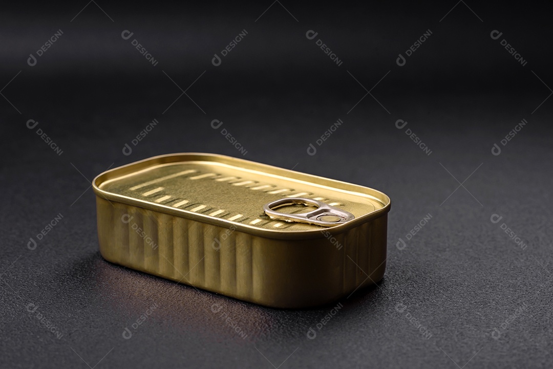 Lata de alumínio metálico de sardinhas enlatadas em óleo com especiarias e sal sobre um fundo escuro de concreto