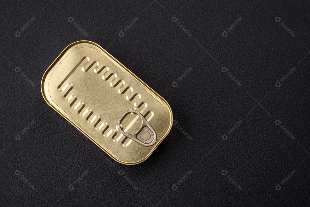 Lata de alumínio metálico de sardinhas enlatadas em óleo com especiarias e sal sobre um fundo escuro de concreto