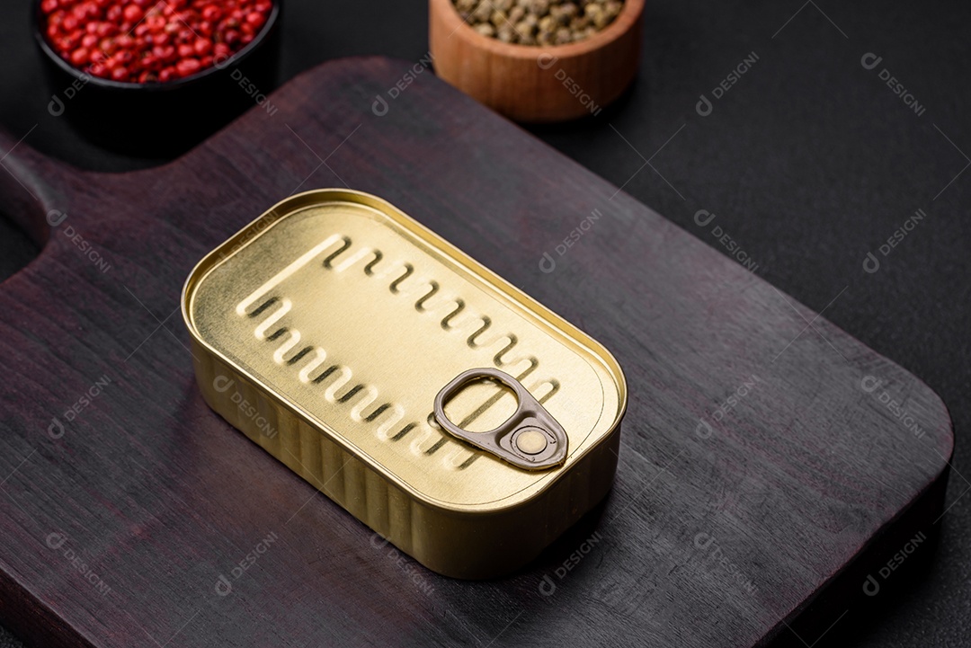 Lata de alumínio metálico de sardinhas enlatadas em óleo com especiarias e sal sobre um fundo escuro de concreto