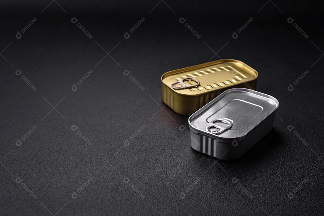 Lata de alumínio metálico de sardinhas enlatadas em óleo com especiarias e sal sobre um fundo escuro de concreto