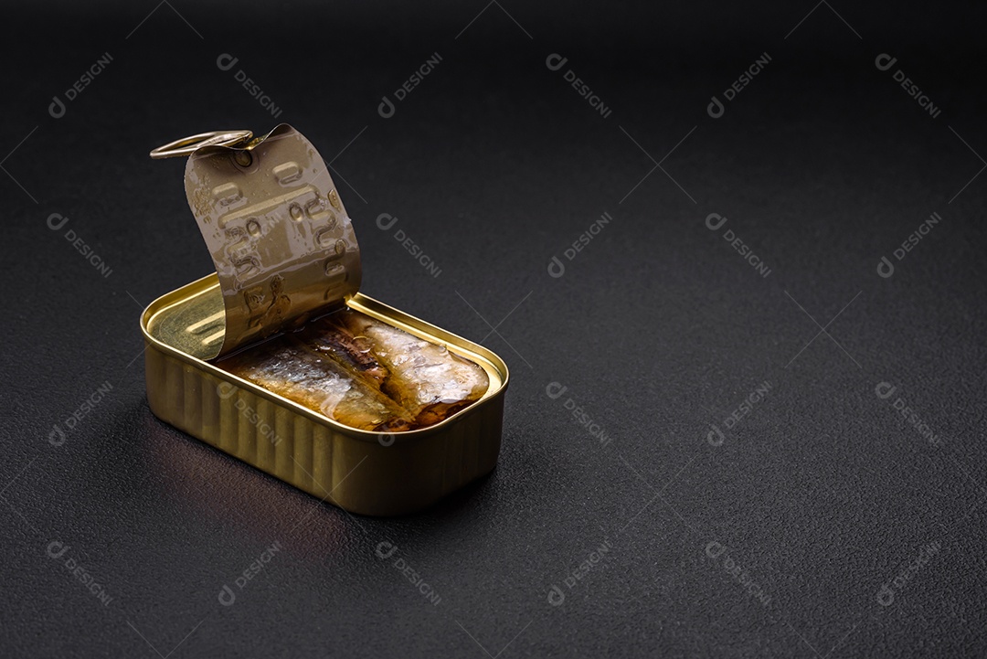 Lata de alumínio metálico de sardinhas enlatadas em óleo com especiarias e sal sobre um fundo escuro de concreto