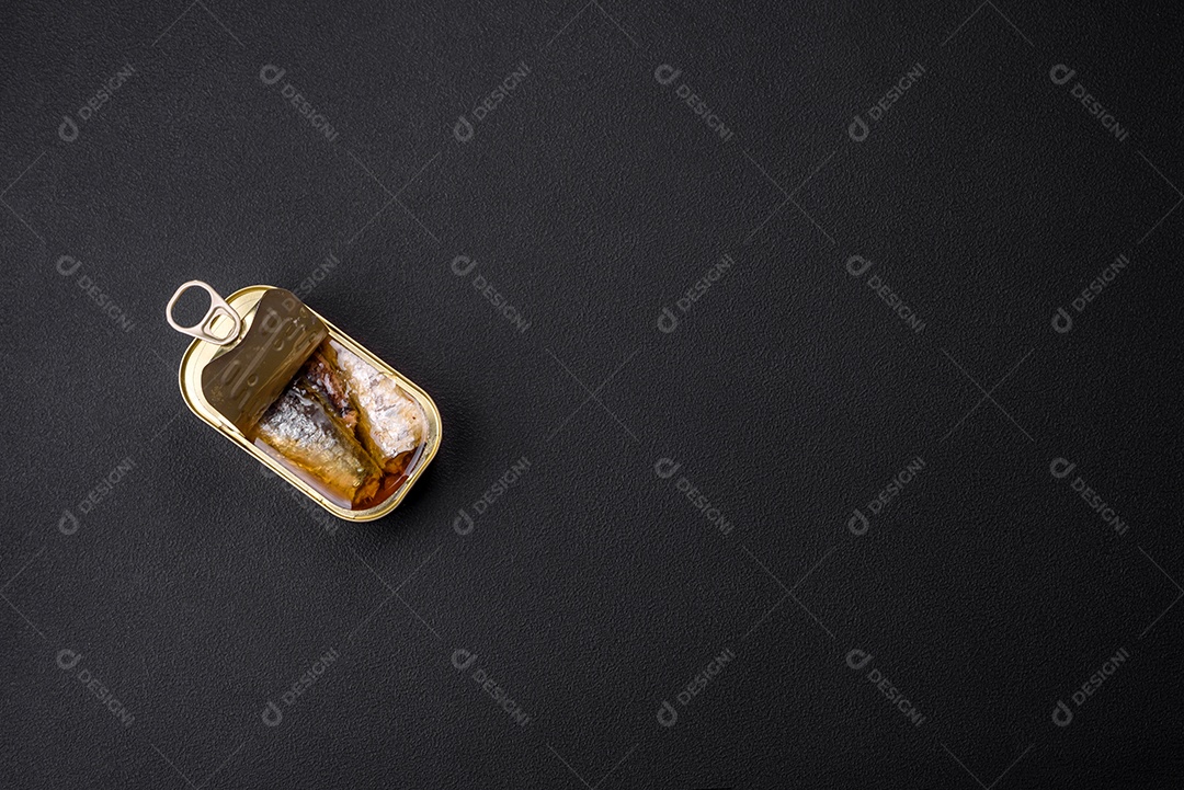 Lata de alumínio metálico de sardinhas enlatadas em óleo com especiarias e sal sobre um fundo escuro de concreto