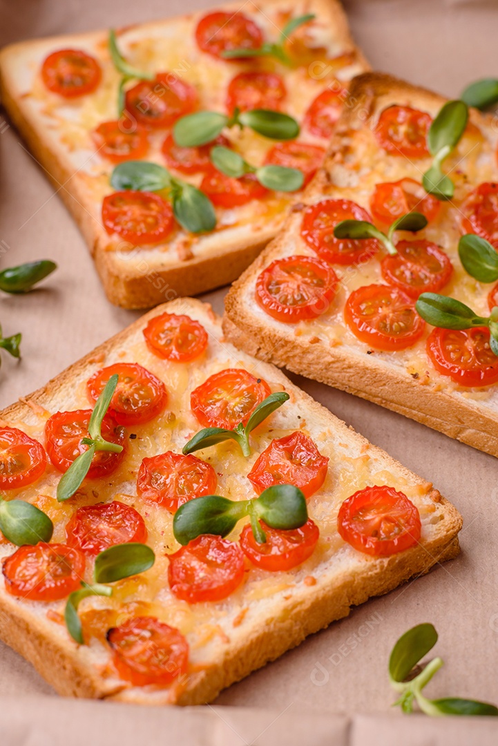 Deliciosa torrada fresca ou bruschetta com tomate, queijo, ervas, sal e especiarias sobre fundo escuro de concreto