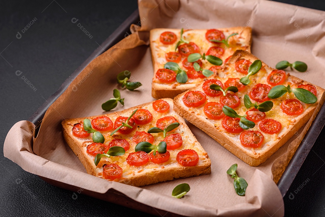 Deliciosa torrada fresca ou bruschetta com tomate, queijo, ervas, sal e especiarias sobre fundo escuro de concreto