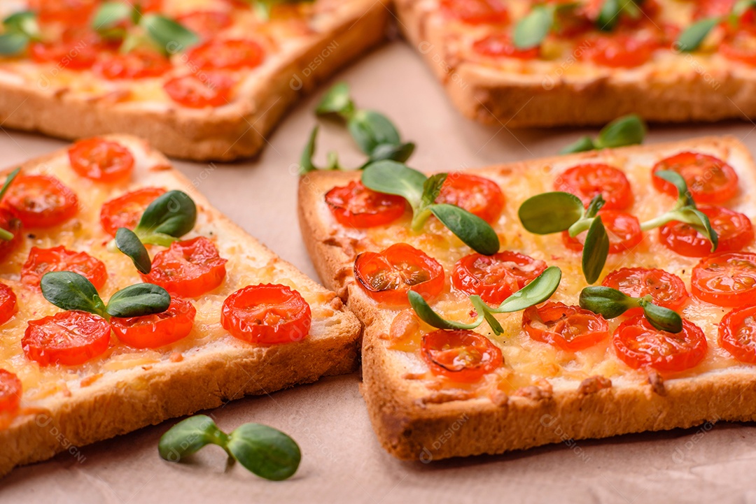 Deliciosa torrada fresca ou bruschetta com tomate, queijo, ervas, sal e especiarias sobre fundo escuro de concreto