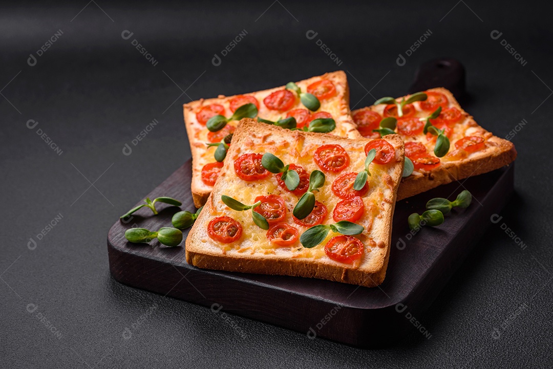 Deliciosa torrada fresca ou bruschetta com tomate, queijo, ervas, sal e especiarias sobre fundo escuro de concreto