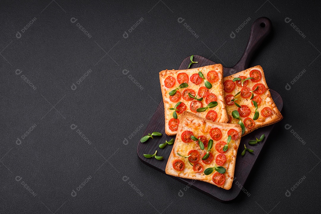 Deliciosa torrada fresca ou bruschetta com tomate, queijo, ervas, sal e especiarias sobre fundo escuro de concreto