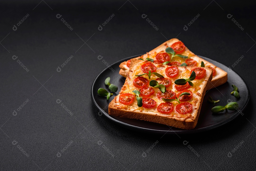Deliciosa torrada fresca ou bruschetta com tomate, queijo, ervas, sal e especiarias sobre fundo escuro de concreto