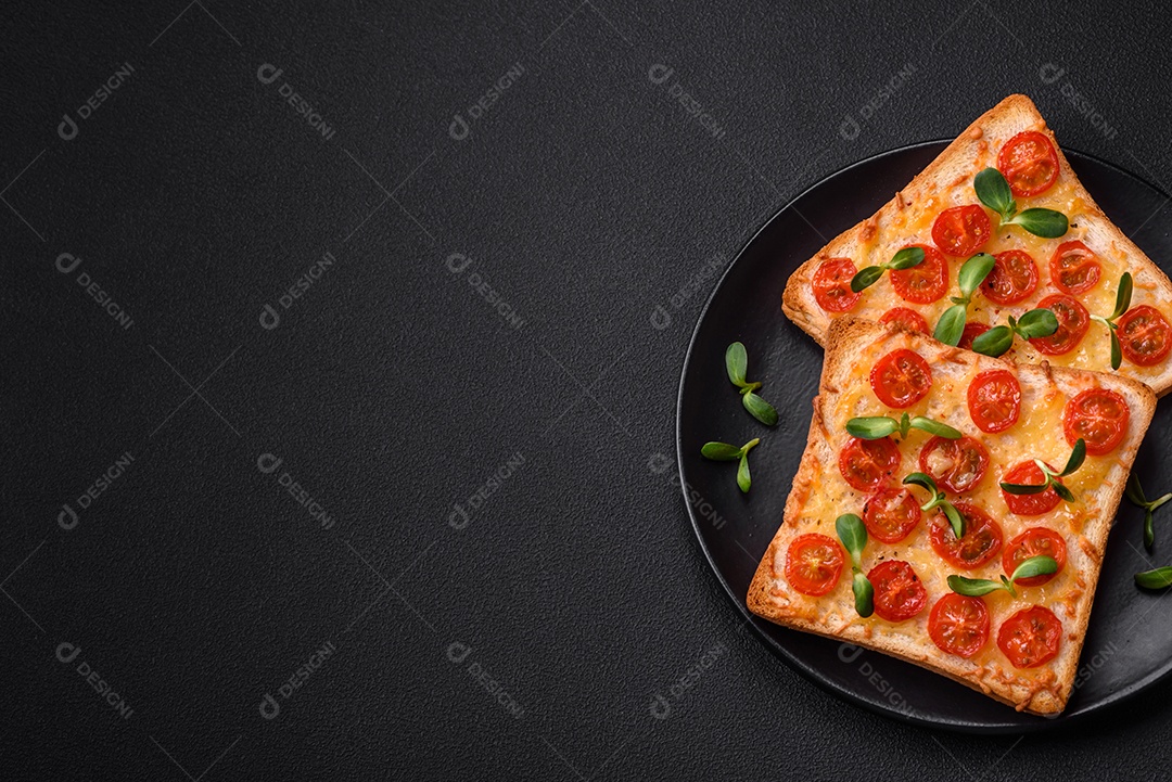 Deliciosa torrada fresca ou bruschetta com tomate, queijo, ervas, sal e especiarias sobre fundo escuro de concreto